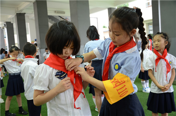 图3 高年级队员指导新队员佩戴红领巾.JPG