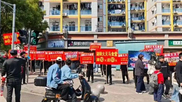湖南一高校食堂在校门口举牌揽客